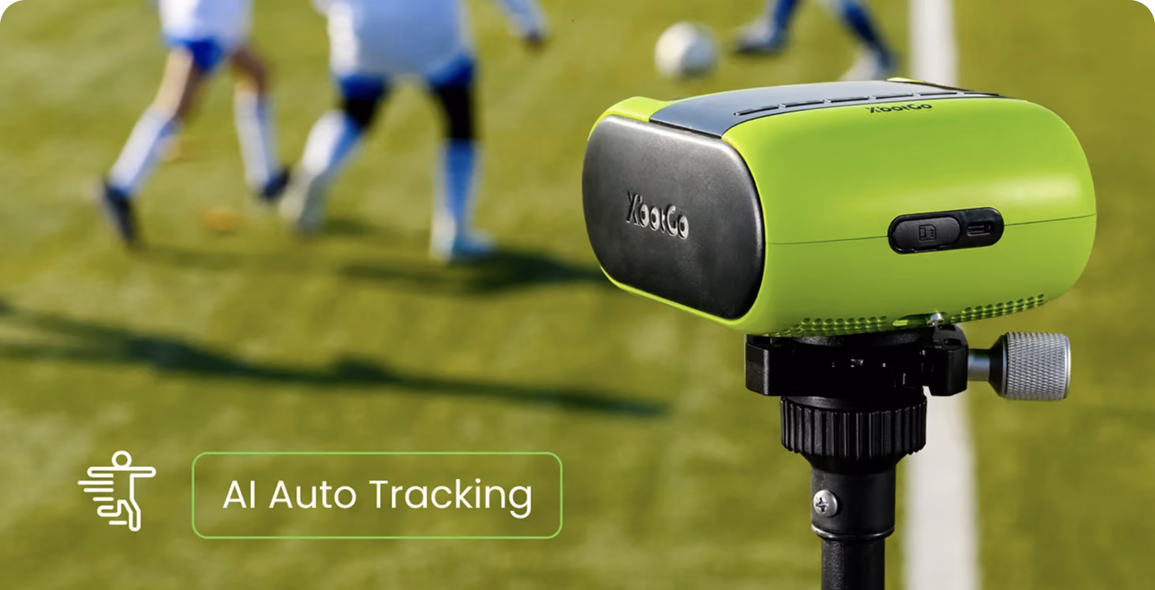 Green AI auto-tracking camera on tripod with blurred soccer players on a field in the background.