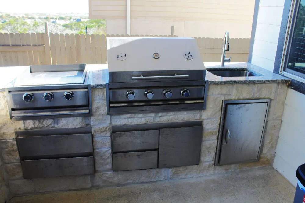 Outdoor kitchen setup with grill and sink.