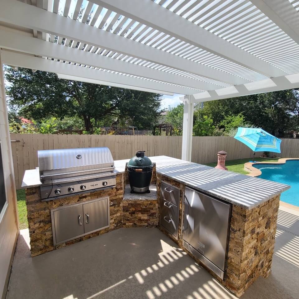 outdoor kitchen below a large white pergola in mahncke park