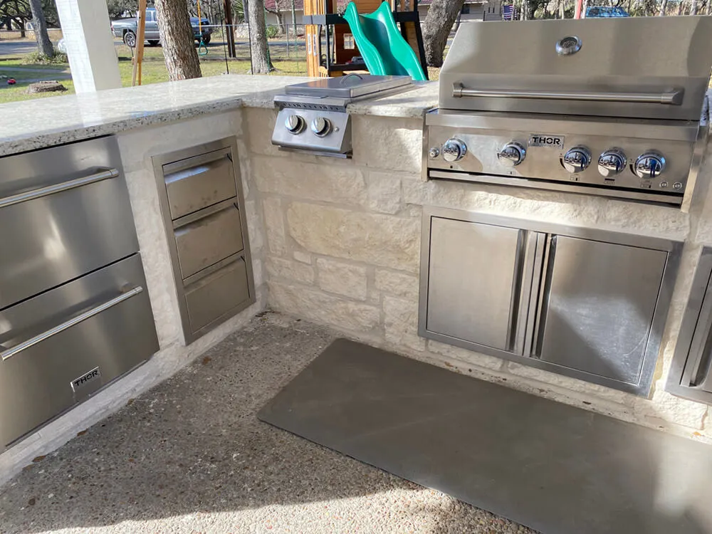 stainless steel appliances adjacent to a white outdoor kitchen
