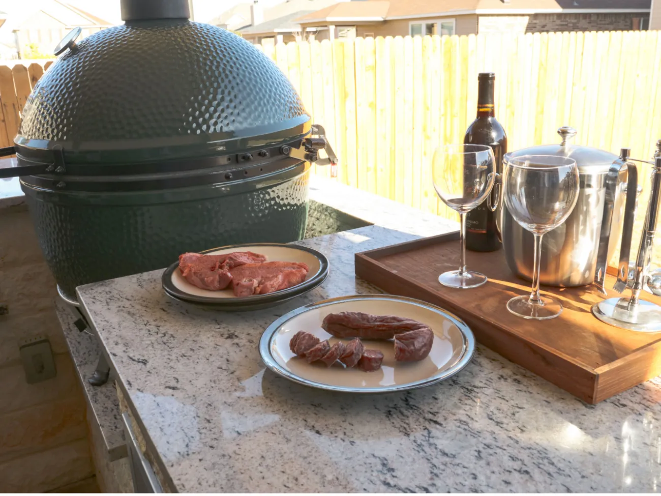 big green egg next to cooked food and wine