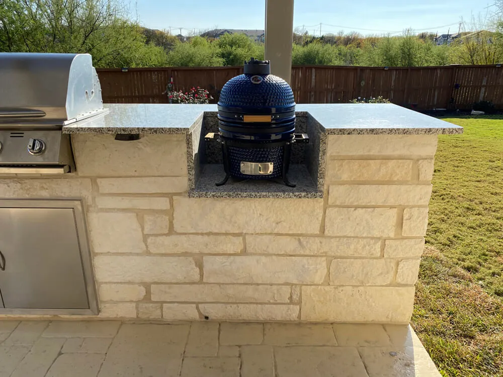 outdoor kitchen with a blue The Big Green Egg kamado grill