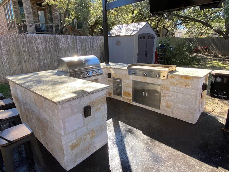 Outdoor kitchen with stone countertops in a San Antonio backyard.