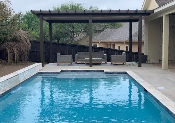 Backyard pool with pergola and seating area in San Antonio.