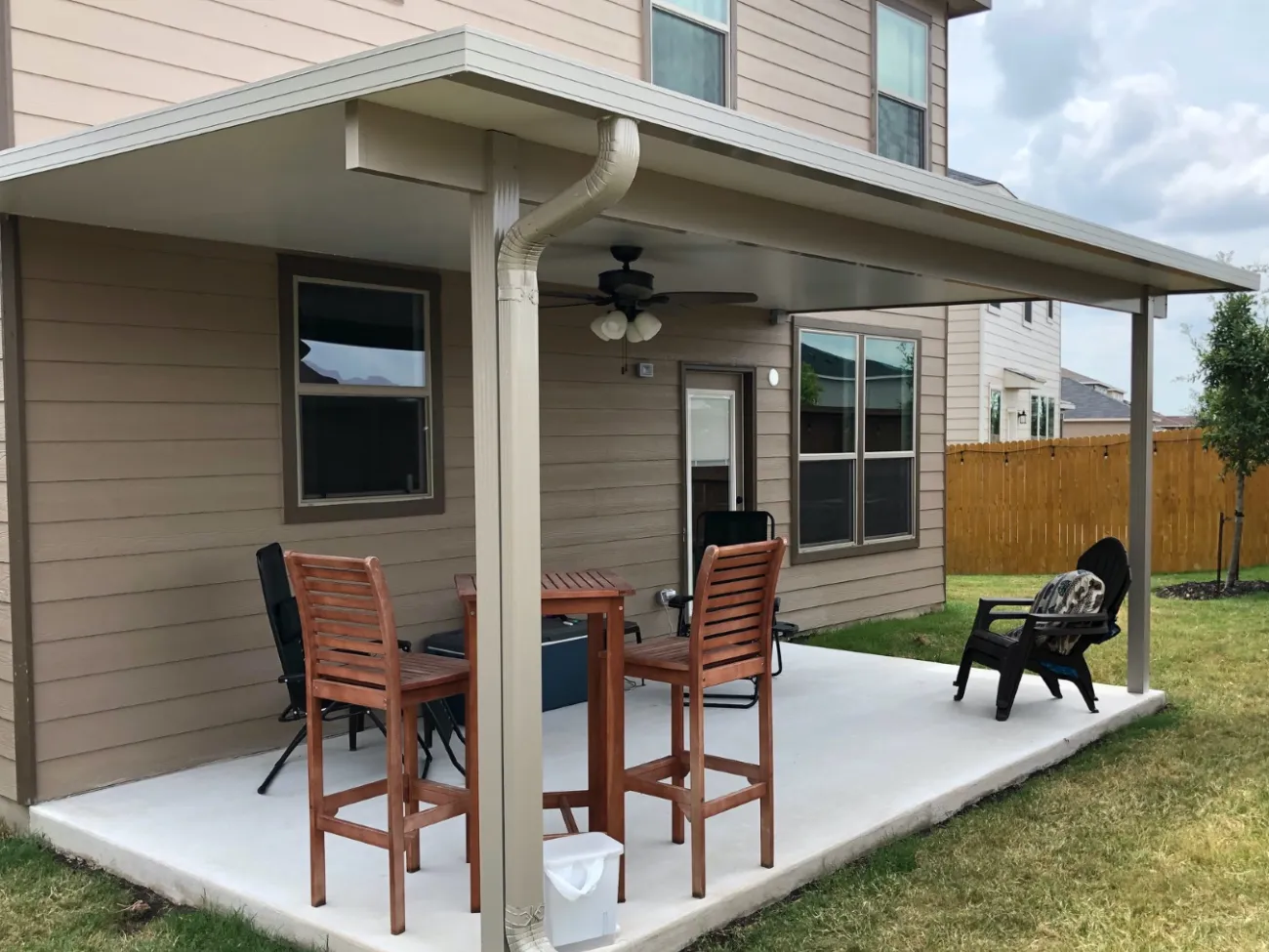 simple white patio cover with stained wood patio furniture