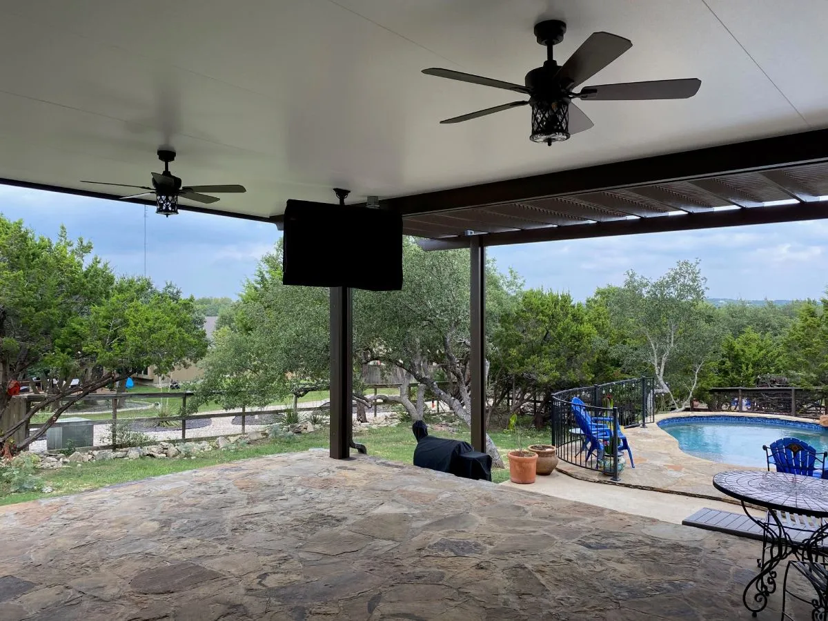 inside a extra large patio cover with fans and a television screen overhead