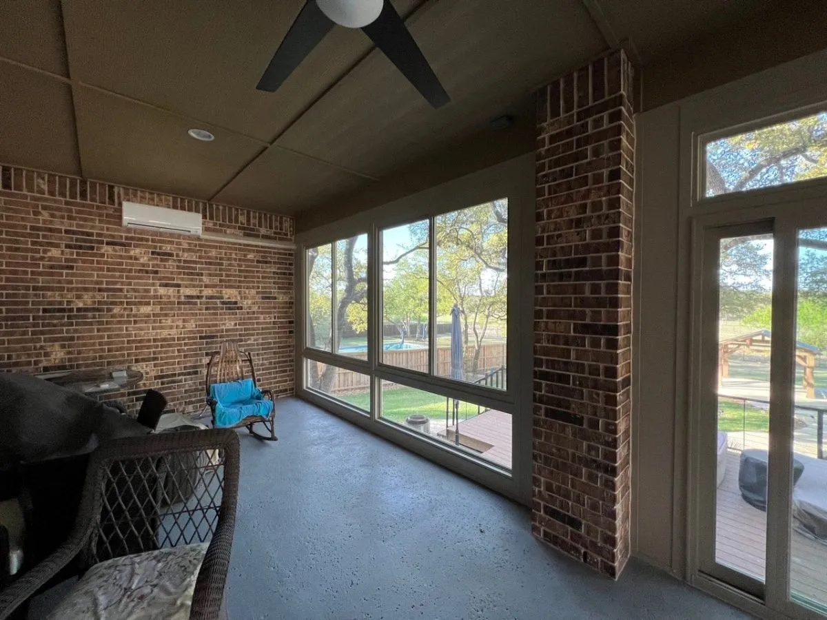 Brick patio enclosure with large windows.