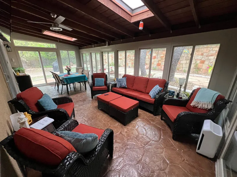 Enclosed patio with red cushioned seating.