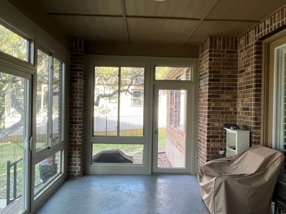 Enclosed brick patio with windows.