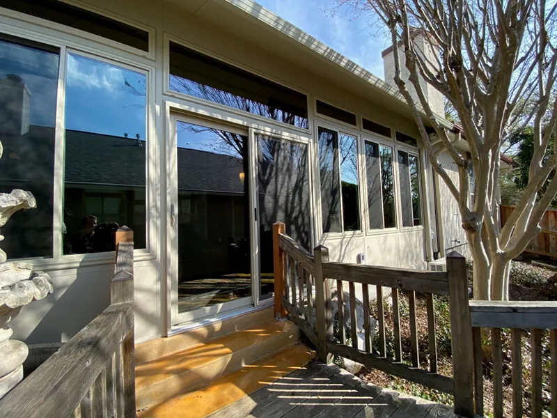 Glass patio enclosure with wooden rails