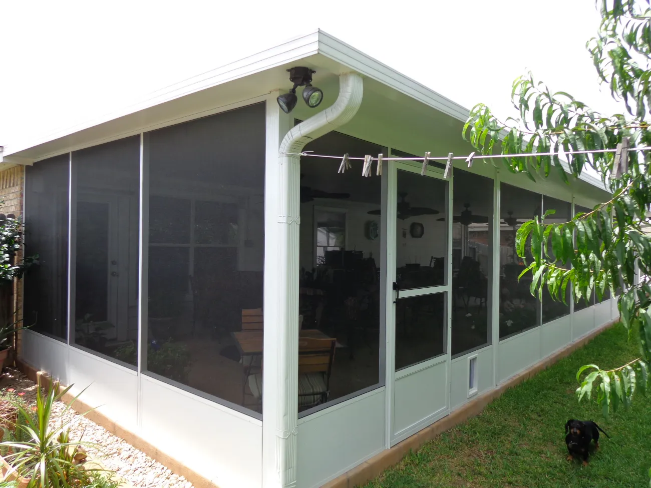 screened in patio with black mesh and white siding