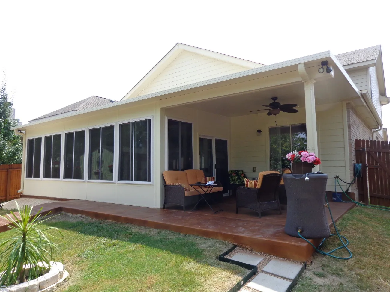 Backyard patio enclosure in San Antonio with seating and ceiling fan.