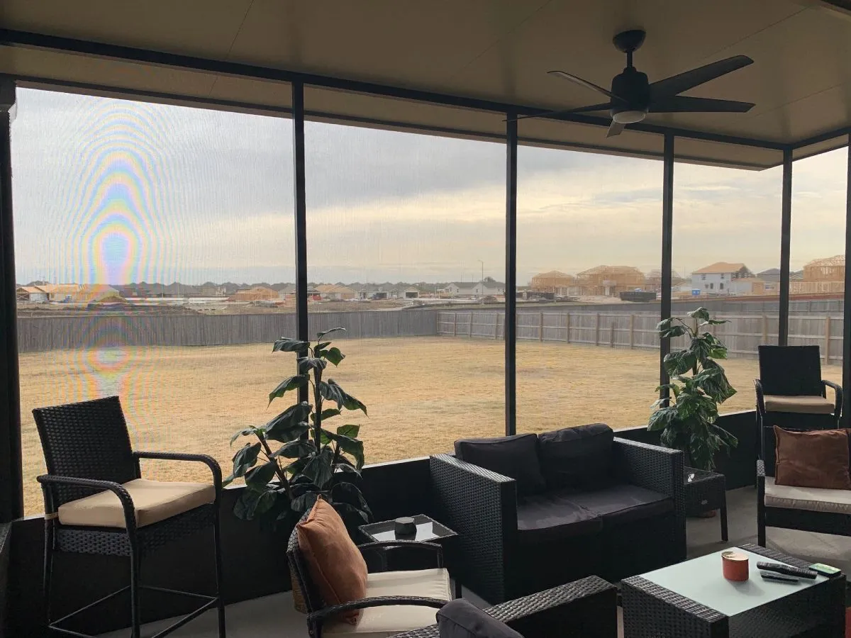 the inside view of patio cover in san antonio that's filled with black wicker patio furniture