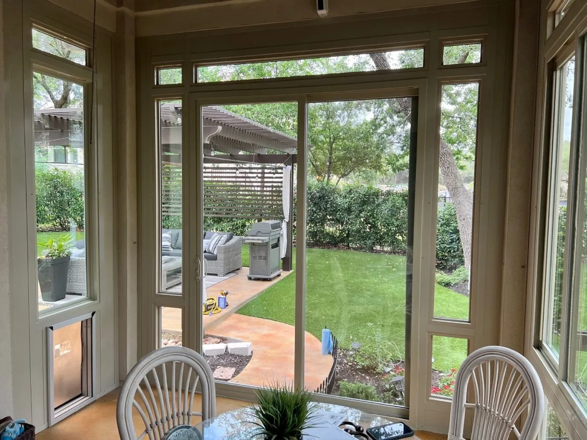 inside of a small sunroom with a glass table and patio chairs
