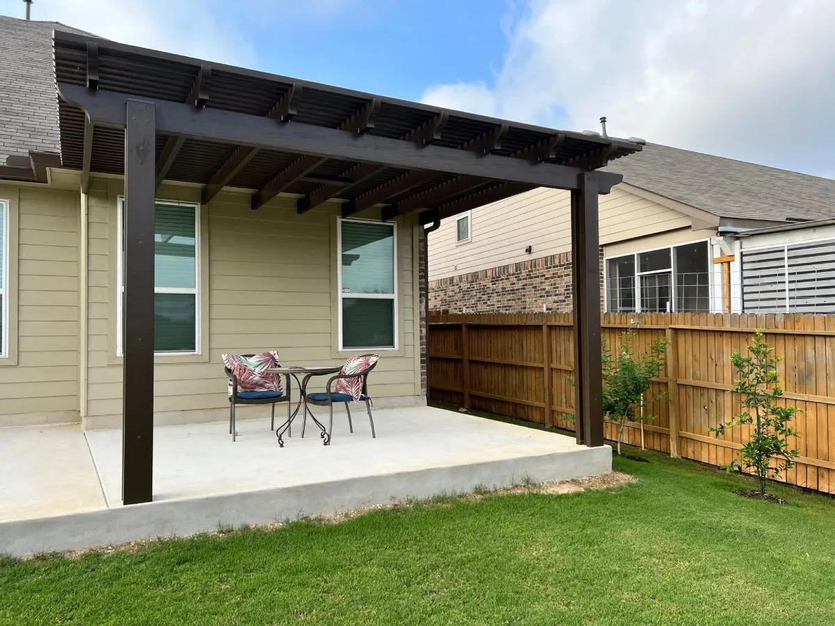 Pergola over patio with chairs, San Antonio backyard.