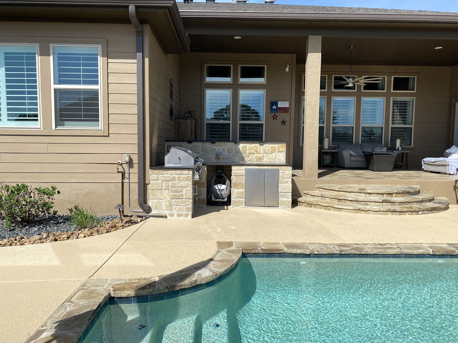 Outdoor kitchen by pool in San Antonio patio.