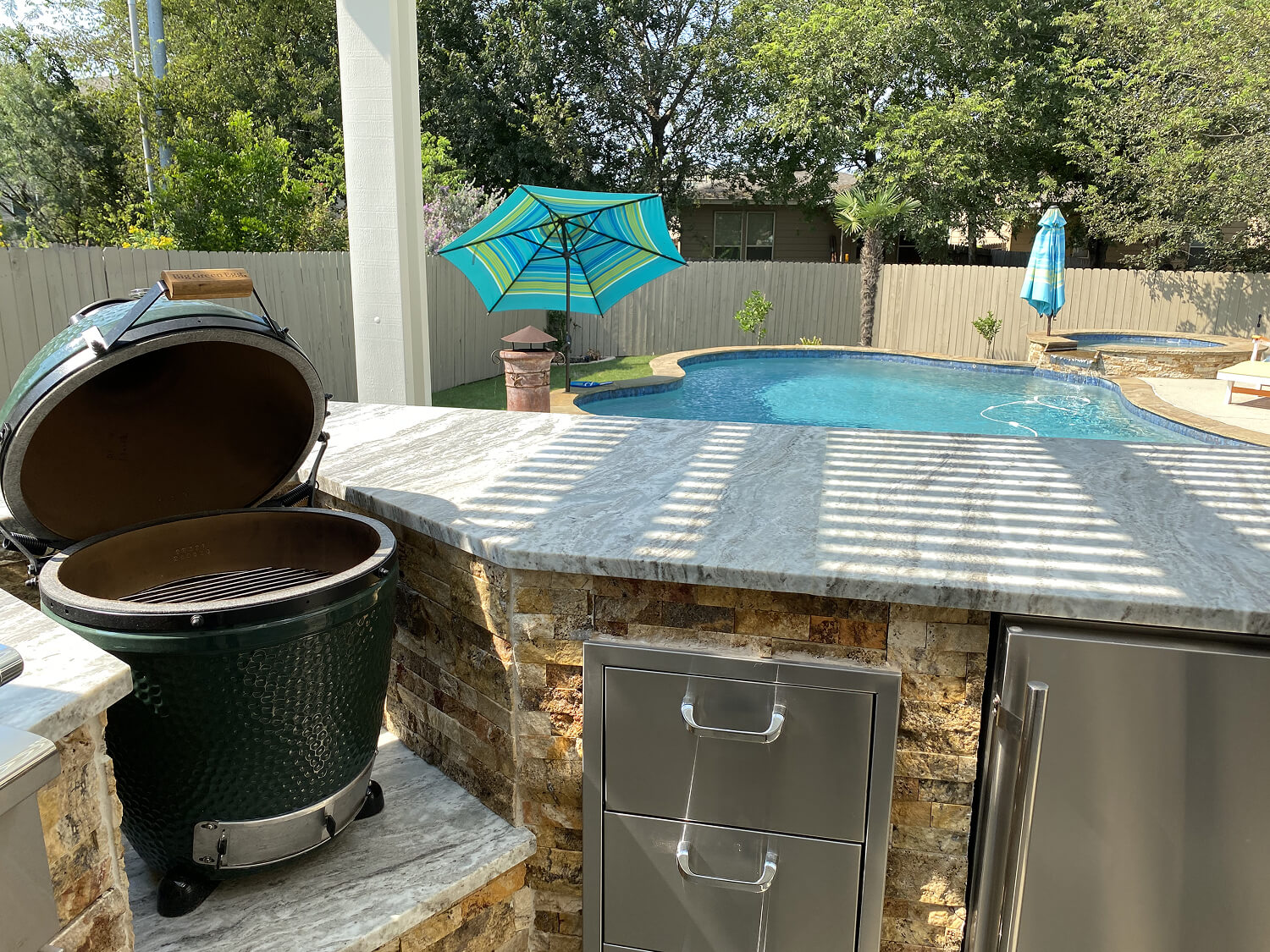 Outdoor kitchen with grill by a pool, San Antonio.