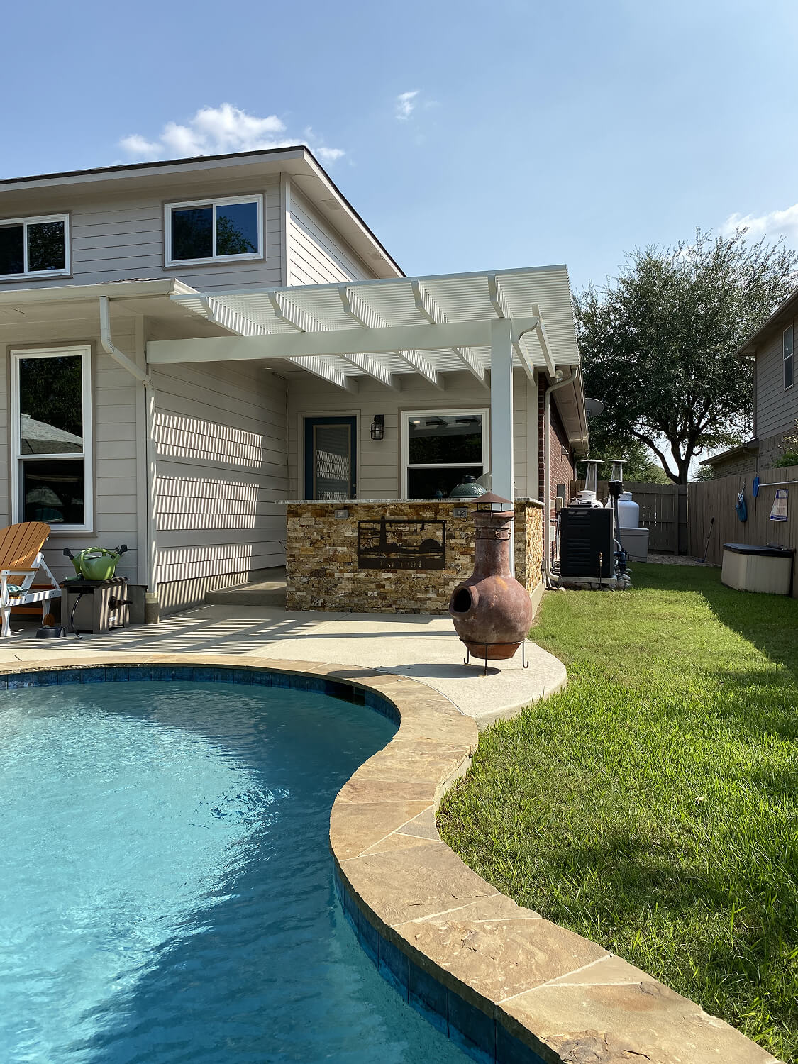 Pergola patio cover over outdoor kitchen by pool, San Antonio.
