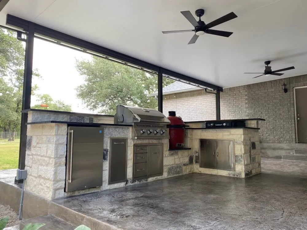 Covered outdoor kitchen with grill and appliances.