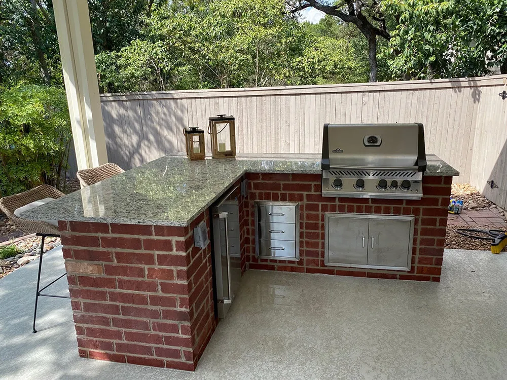 Outdoor kitchen with grill in San Antonio backyard.