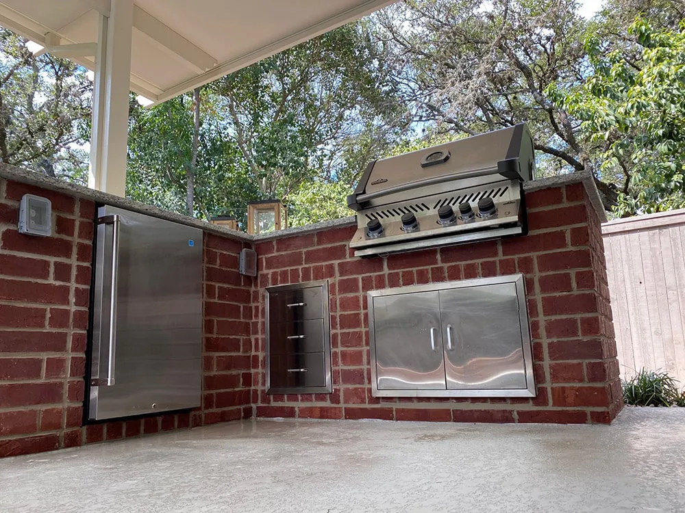 Brick outdoor kitchen with grill and fridge