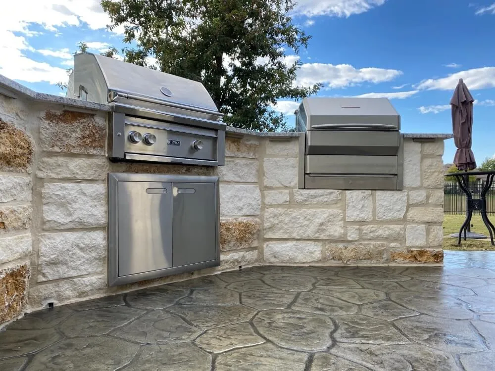 Outdoor kitchen with built-in grill and cabinetry, San Antonio sky.