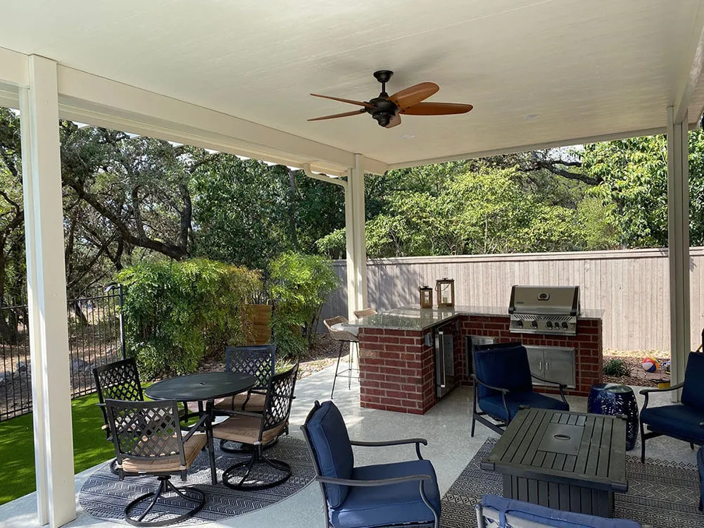 Covered patio with outdoor kitchen and seating area.