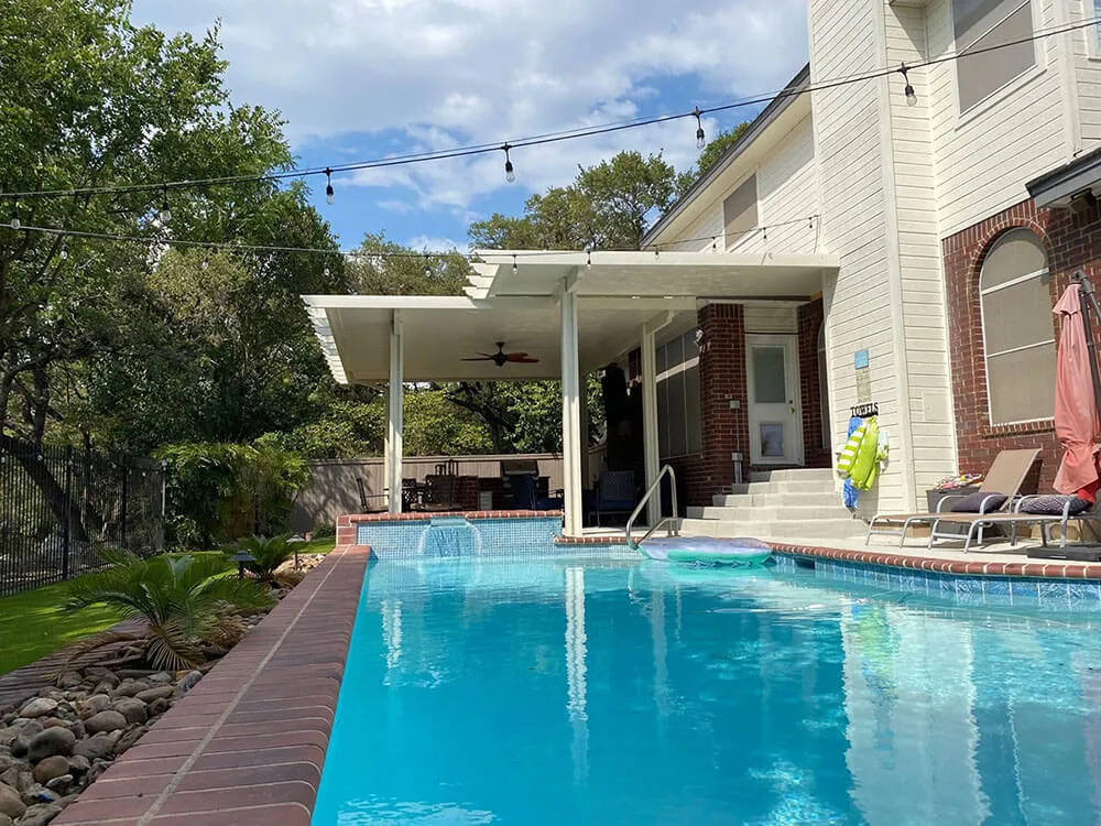 Backyard with pool, covered patio, and outdoor seating.