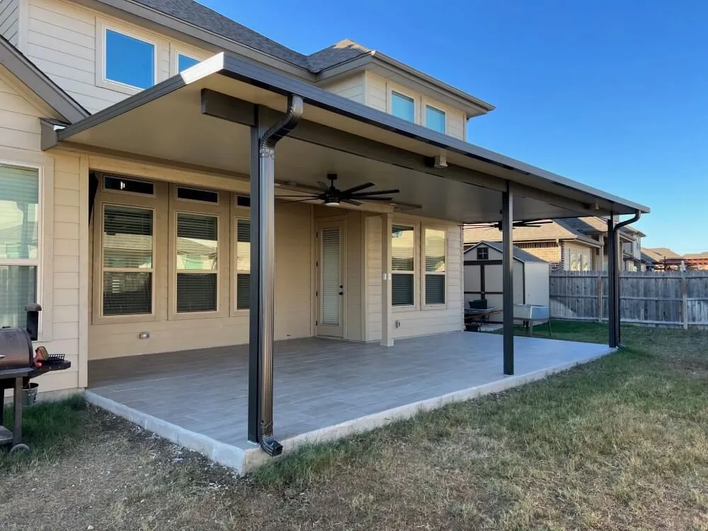 Patio cover on house with tiled floor, outdoor fan.