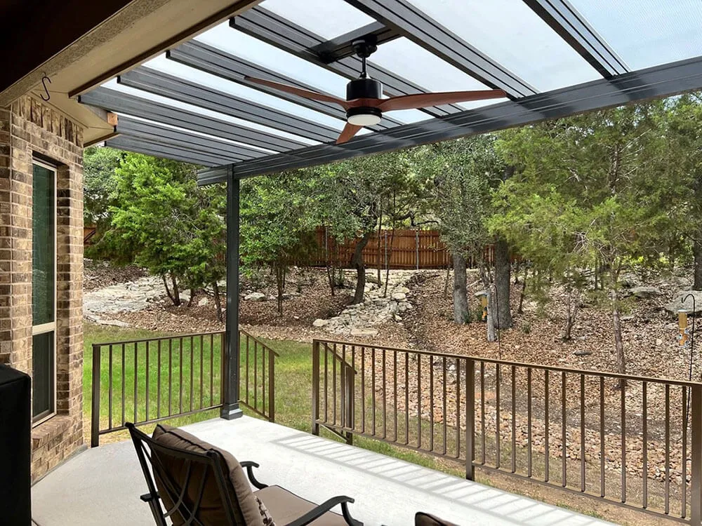 Covered patio with metal railings and outdoor fan, San Antonio yard.