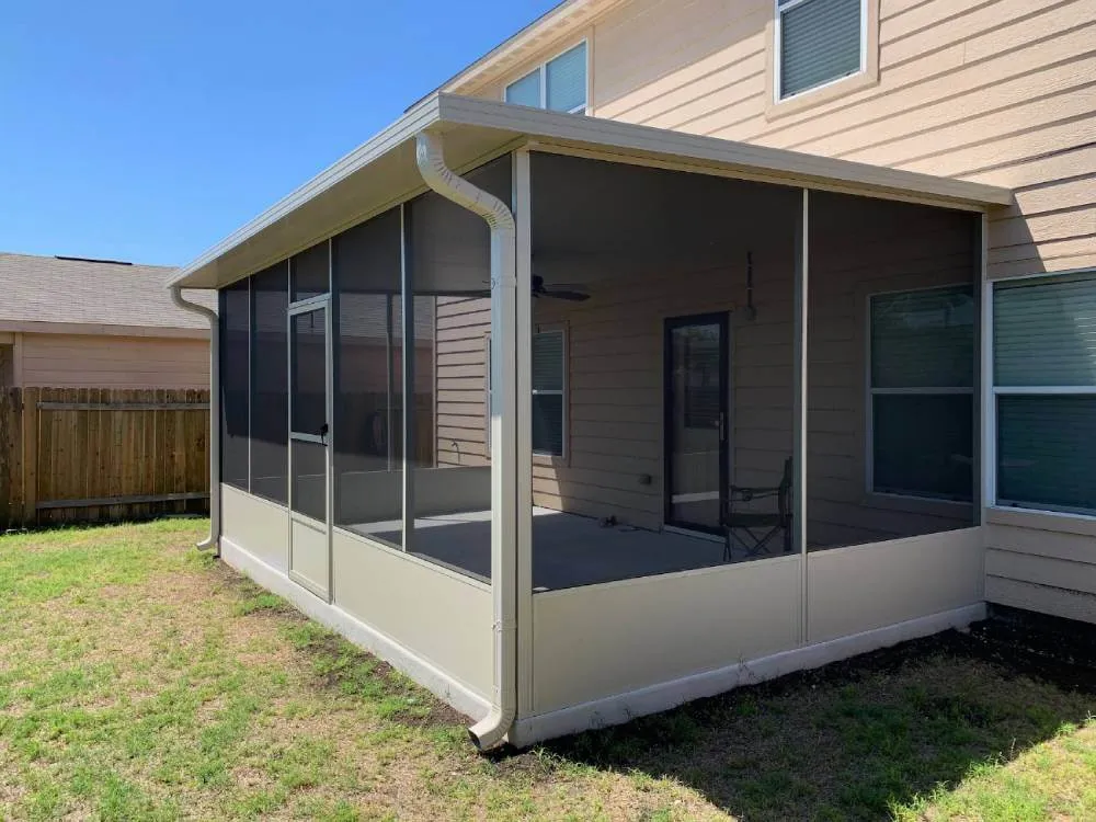 a standard size screened in patio enclosure next to a single family home in san antonio