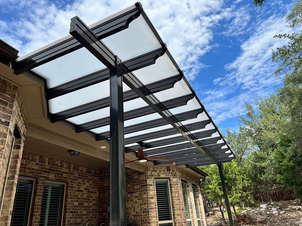 Modern patio cover attached to brick house.