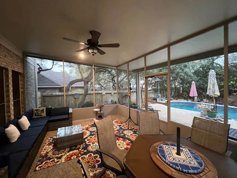Screened patio with outdoor seating by pool.