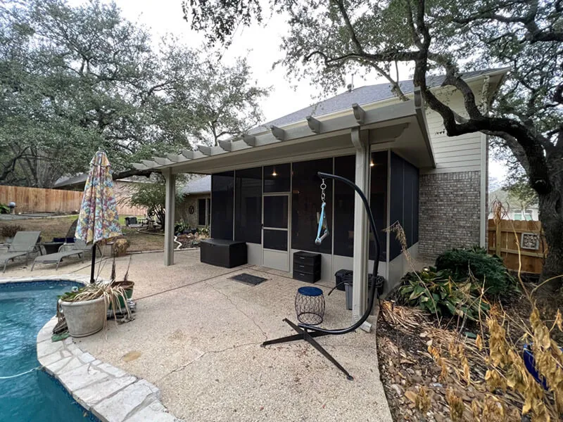Screened patio with custom pergola next to pool in San Antonio backyard.