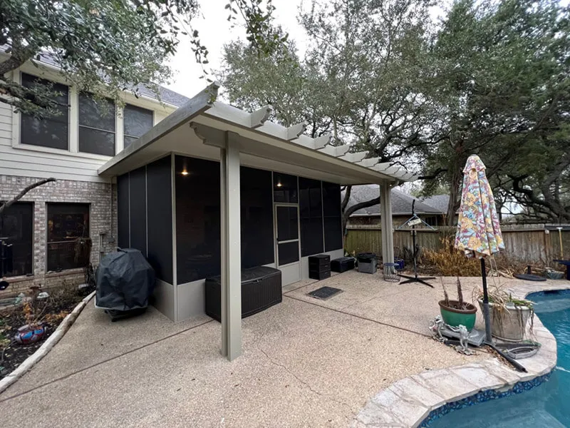Screened patio enclosure next to a house and pool in San Antonio.