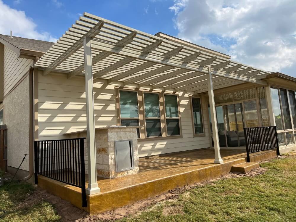 Cream pergola over patio with stone grill in San Antonio.