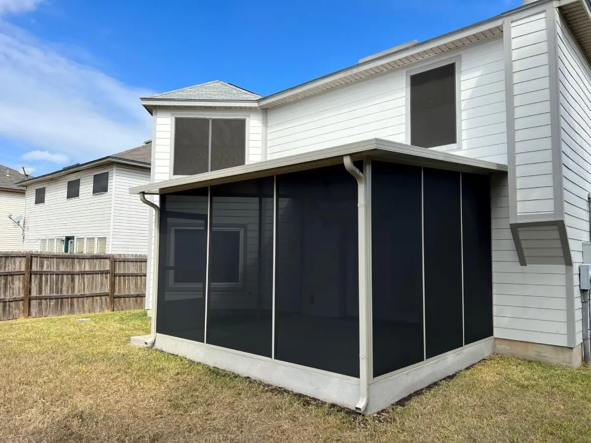 Screened patio enclosure attached to white house in San Antonio.