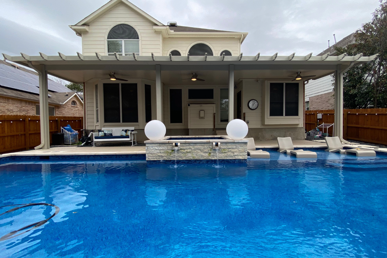 Backyard pool with decking and modern house.