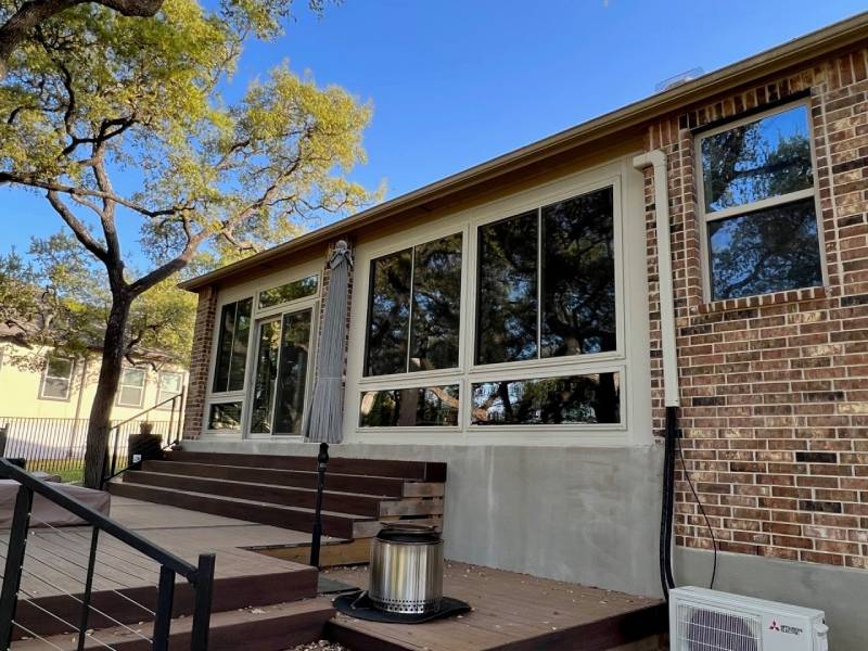 Patio enclosure with large windows and wooden deck in San Antonio.