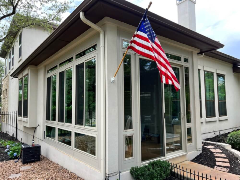Modern home with patio enclosure and American flag.