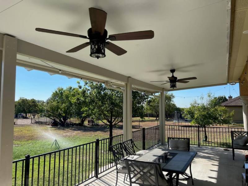 Outdoor patio with ceiling fans and seating area.