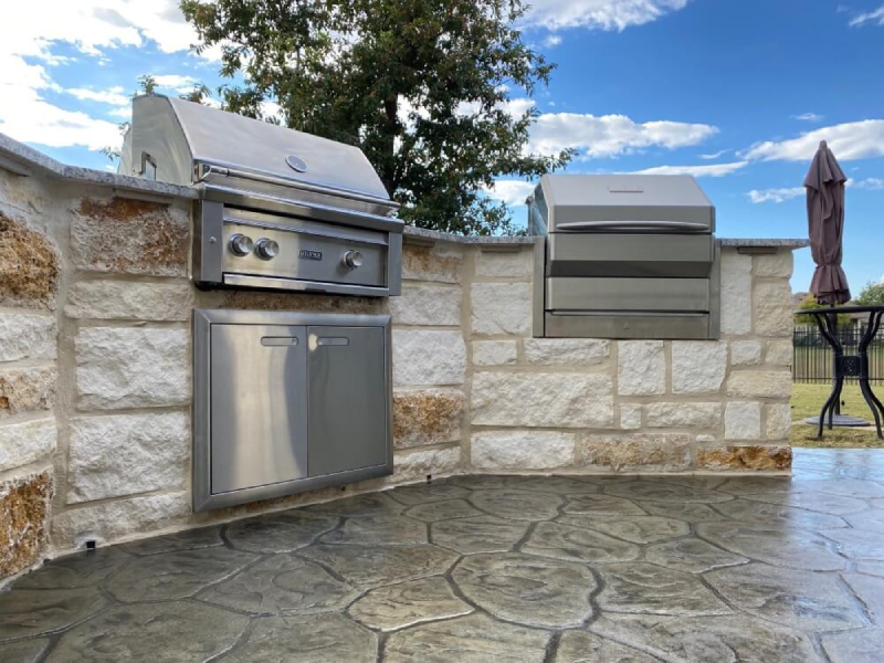 Outdoor kitchen with stainless steel appliances on a patio in San Antonio.
