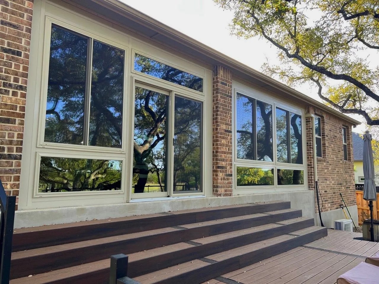 Patio enclosure in San Antonio with large windows and wooden steps.