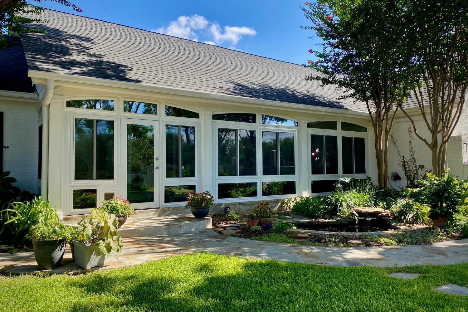 Sunroom with large windows and garden in San Antonio.