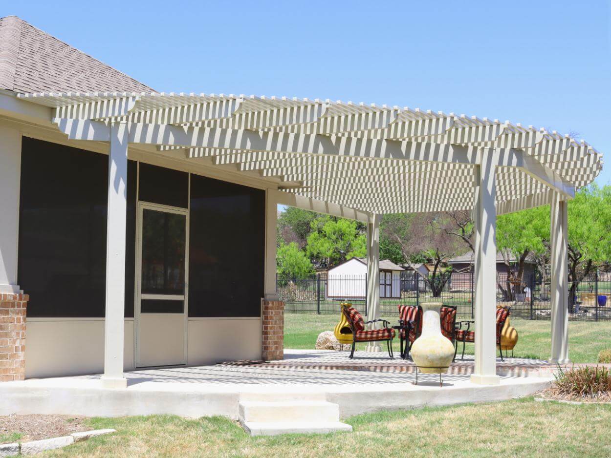 Wide white patio cover in San Antonio with seating area.