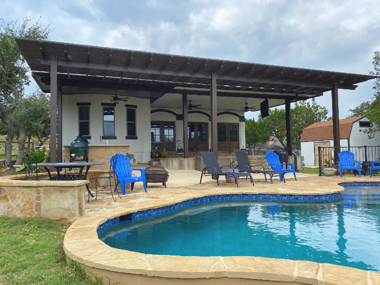 Patio cover in San Antonio next to a large pool.