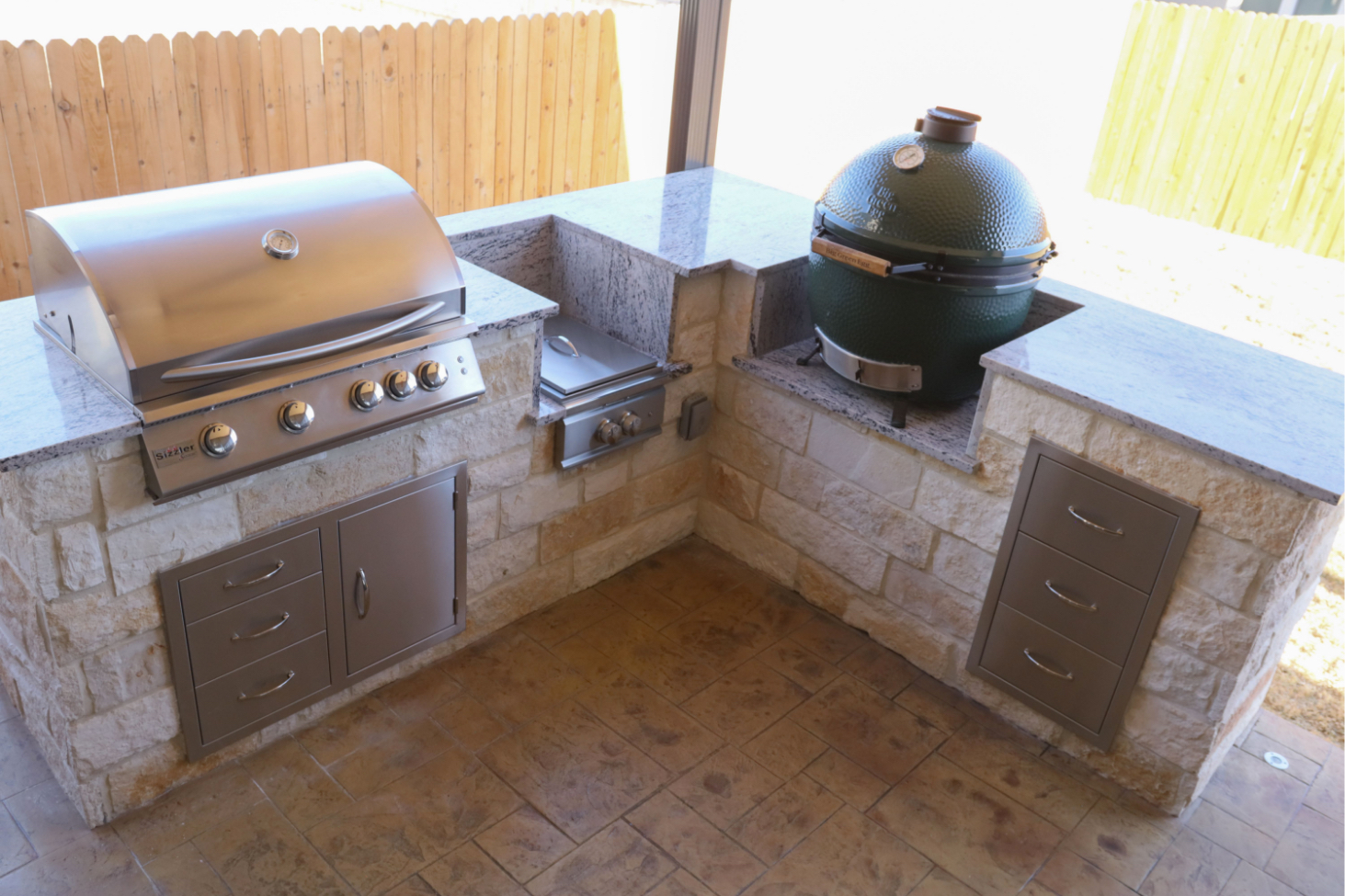 Outdoor kitchen with grill and smoker setup.