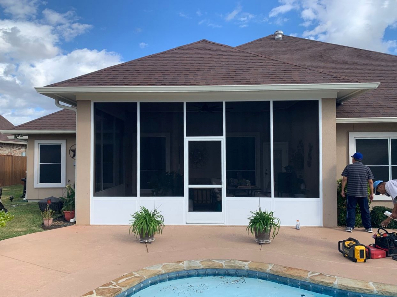 Home exterior with screened patio and landscaping.