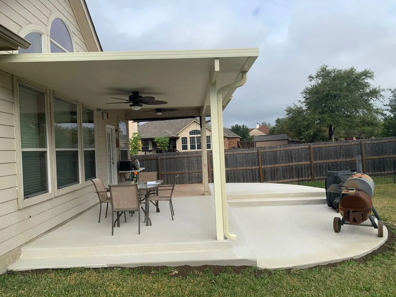 Concrete patio with white patio cover in woodlawn lake