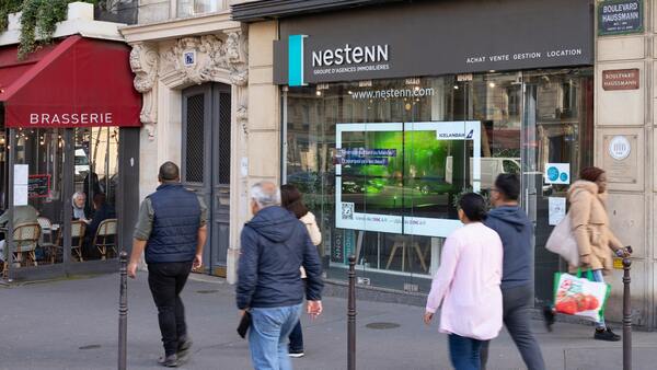Écran DOOH placé à un carrefour fréquenté en centre-ville pour maximiser la visibilité des annonces.